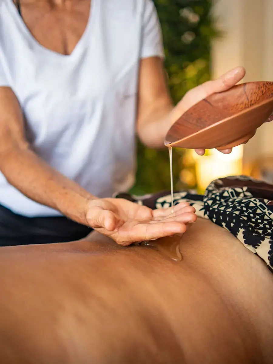 Massage oil being poured during a treatment